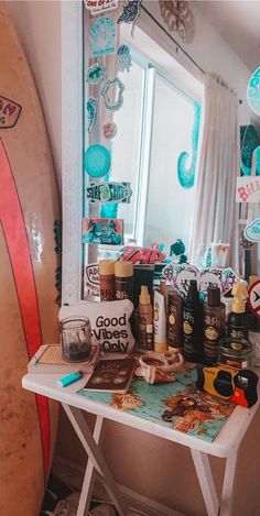 a surfboard sitting on top of a table next to a mirror and other items