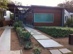 a house with a walkway leading to the front door and side yard area next to it