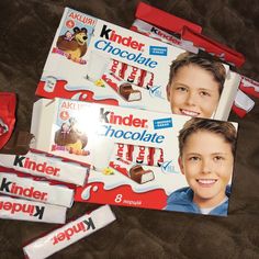 two boxes of kinder chocolate are laying on the floor next to some candy bars