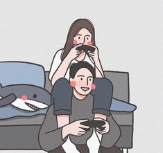 two people are sitting on the couch playing with remote controls in front of their faces