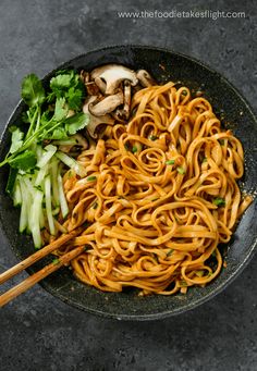 noodles and vegetables in a wok with chopsticks