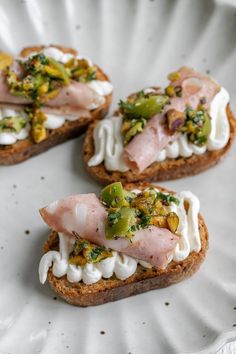 three pieces of bread topped with meat and veggies on top of each other