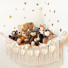 stuffed animals in a crib with stars on the wall behind it and a string curtain hanging from the ceiling