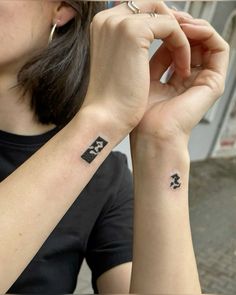 a woman with two small tattoos on her arms