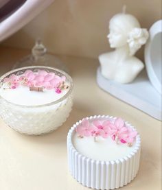 two small white dishes with pink flowers on them