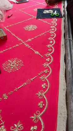 the table is covered with pink cloth and gold trimmings, along with other items