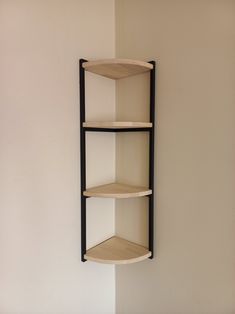 a corner shelf with three shelves mounted on the wall next to a white painted wall