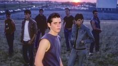 a group of young men standing next to each other in a field at sunset or dawn