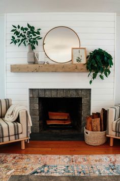 a living room with a fire place and some plants on top of the mantel