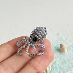 a tiny beaded crab is held in someone's hand