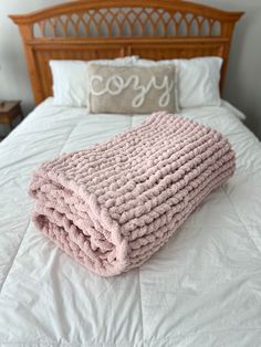 a pink blanket on top of a white bed