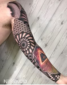 a man's arm with an all seeing eye tattoo on the left forearm and half sleeve