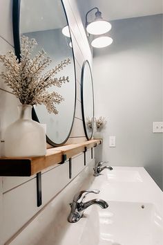 a white sink sitting under a bathroom mirror next to a wall mounted faucet