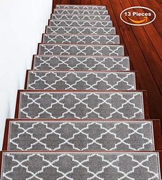 a set of four gray and white rugs sitting on top of a wooden floor