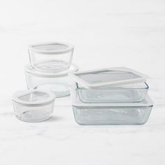 glass containers with lids and lids on a marble surface