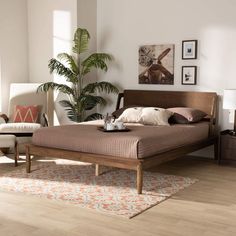 a bed sitting in a bedroom next to two chairs and a table on top of a wooden floor