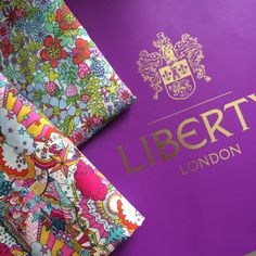 the liberty london tie is laying on top of a purple book with an ornate design