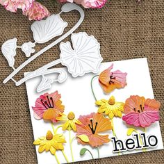 a card with flowers on it and the word hello written in black ink next to some cut outs