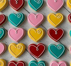 many heart shaped cookies are arranged on a table