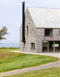 a stone building with two windows on the front and one in the back that is made out of wood