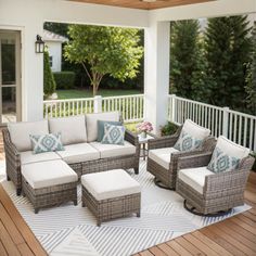 an outdoor living room with furniture on the deck