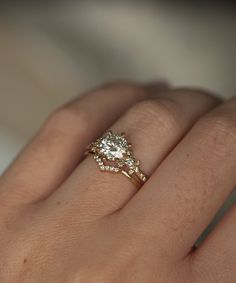 a woman's hand with a diamond ring on top of her finger and an engagement band