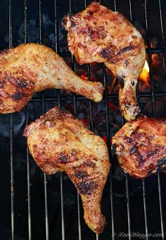 four pieces of chicken cooking on the grill