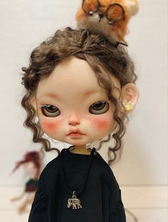 a close up of a doll with glasses on her head