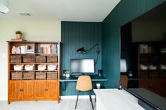 a living room filled with furniture and a flat screen tv sitting on top of a wooden shelf