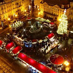 an aerial view of a christmas market in the middle of a city at night time