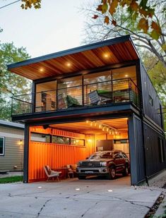 a truck is parked in front of a shipping container with its doors open and lights on