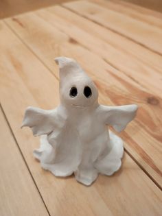 a white ceramic figurine sitting on top of a wooden floor