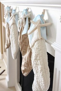 stockings hung on the mantle in front of a fireplace with seashells and starfish