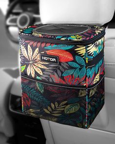 the interior of a car with a colorful floral print bag hanging from it's center console