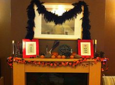 a mantel decorated for halloween with pumpkins and other decorations