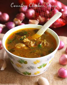 chicken soup in a bowl with garlic on the side