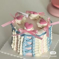 a decorated cake with pink, blue and white icing