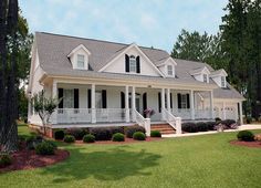 a large white house sitting on top of a lush green field