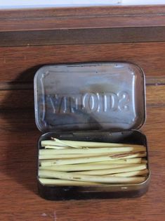 an open tin with toothpicks in it sitting on a table