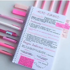 a notebook with writing on it next to some pens and magnets in pink ink