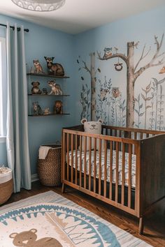 a baby's room decorated in blue and white with trees on the wall, teddy bears