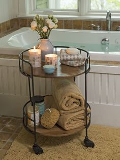 a bathroom with a tub, towels and candles