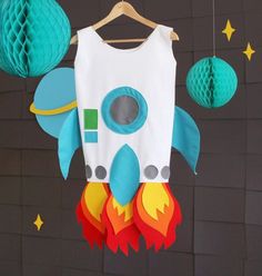 a paper rocket ship mobile hanging from a string with blue lanterns and stars around it