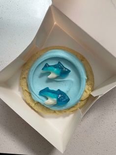 a cookie with blue icing in a white box