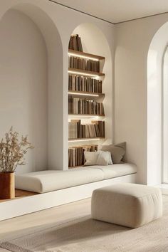 a living room filled with white furniture and bookshelves next to a large window