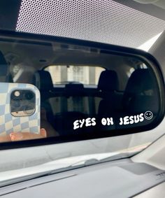 a person taking a selfie in the side mirror of a car with their cell phone