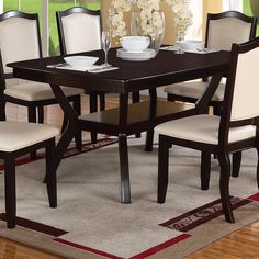 a dining room table with white chairs around it