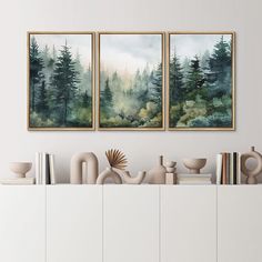 two paintings on the wall above a white cabinet with books and vases in front of it