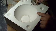 a person is working on a toilet in the process of being built into a box