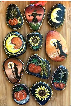 painted pumpkins are arranged on a wooden surface with the moon and sun in the background